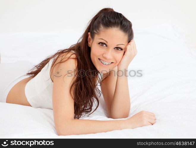 Brunette young woman resting in her bed