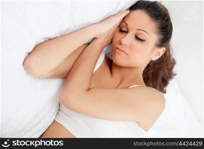Brunette young woman sleeping in her bed