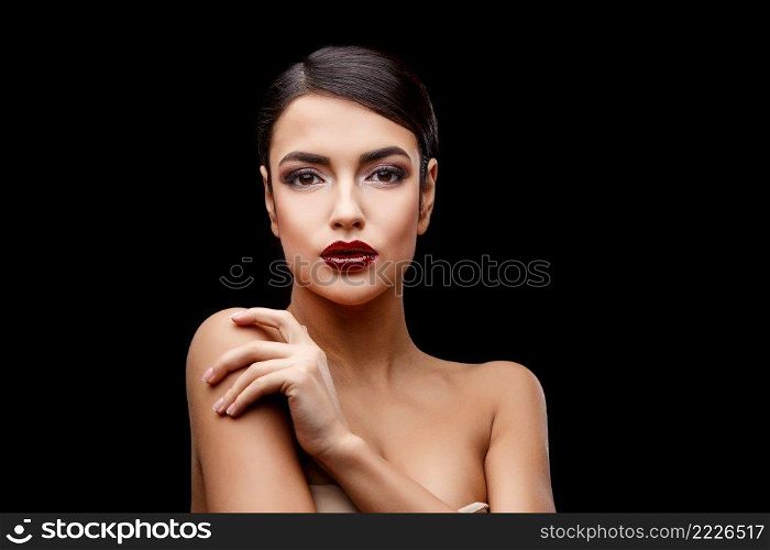 Brunette young woman with beautiful clean skin isoilated on dark background. Young brunette woman with beautiful clean skin