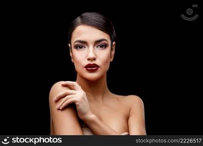 Brunette young woman with beautiful clean skin isoilated on dark background. Young brunette woman with beautiful clean skin