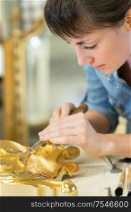 brunnette woman paints with gold