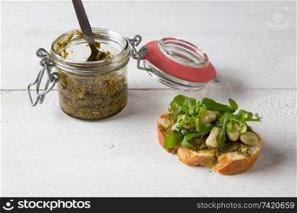 Bruschetta with beans and arugula on a wooden board.. Bruschetta with beans and arugula on a wooden board