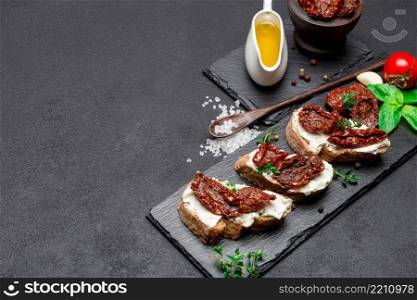 bruschetta with Canned Sundried or dried tomato halves and cream cheese on stone serving board. bruschetta with Canned Sundried or dried tomato halves on stone serving board