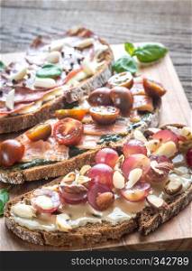 Bruschetta with different toppings on the wooden board