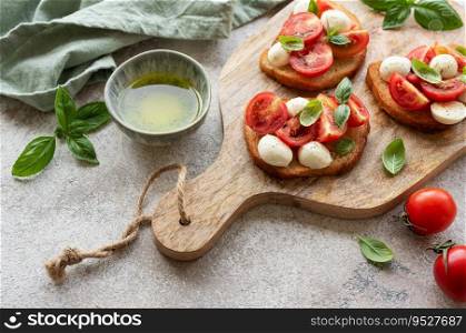 Bruschetta with fresh tomatoes, basil and mozzarella cheese on a wooden board. 