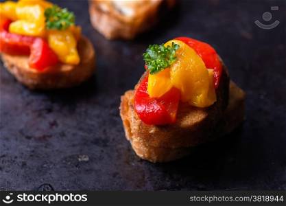 Bruschetta with grilled bell pepper over old dark tray, selective focus