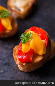 Bruschetta with grilled bell pepper over old dark tray, selective focus