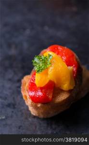 Bruschetta with grilled bell pepper over old dark tray, selective focus, copy space