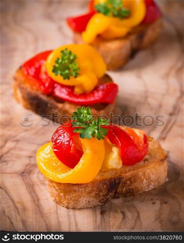 Bruschetta with grilled bell pepper over olive wood board, selective focus