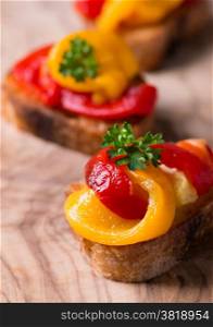 Bruschetta with grilled bell pepper over wooden board, selective focus
