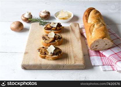 Bruschetta with mushrooms on a wooden board.. Bruschetta with mushrooms on a wooden board