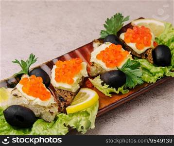 Bruschetta with red caviar on a plate