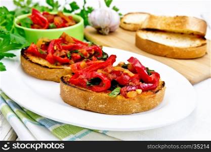 Bruschetta with roasted tomatoes, peppers, garlic, onions and parsley in a plate on a napkin against the background of wooden boards