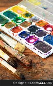 Brush and paint. Set of watercolors and different brushes for painting on wood vintage palette