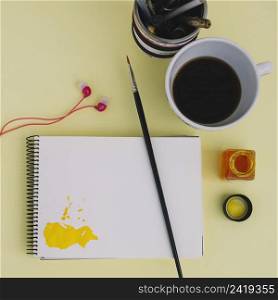 brush notebook near coffee earphones