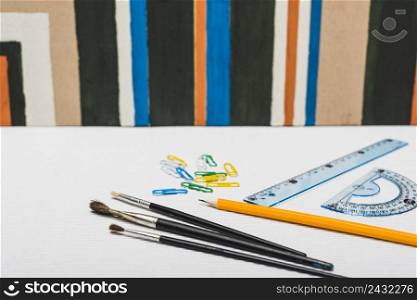 brushes stationery near abstract painting