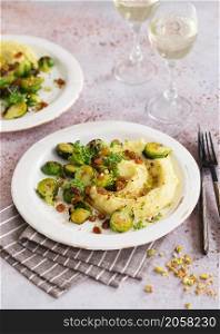 Brussels sprouts with pistachios, raisins and Skordalia (mashed potatoes). Healthy Meal preparation. Plant-based dishes. Green living. Vegan recipe. Food styling. Vegetarian cuisine. Healthy eating