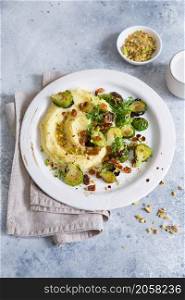 Brussels sprouts with pistachios, raisins and Skordalia (mashed potatoes). Healthy Meal preparation. Plant-based dishes. Green living. Vegan recipe. Food styling. Vegetarian cuisine. Healthy eating