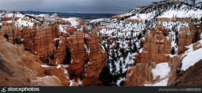 Bryce canyon panorama in overcast winter day with brown rocks and snow