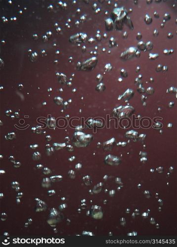 bubbles in water, red background, image used for graphic background.