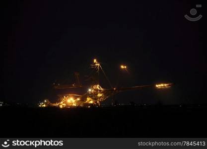 bucket wheel excavator digging for brown coal night view Poland extractive industry