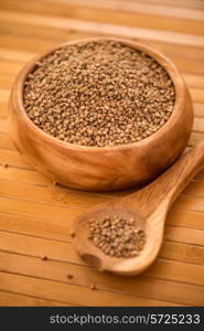 buckwheat at wooden plate on wooden background