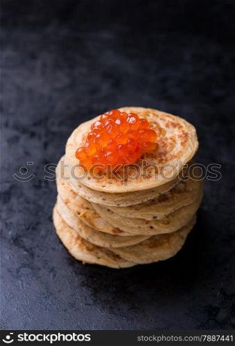 Buckwheat blini with red caviar and sour cream, selective focus