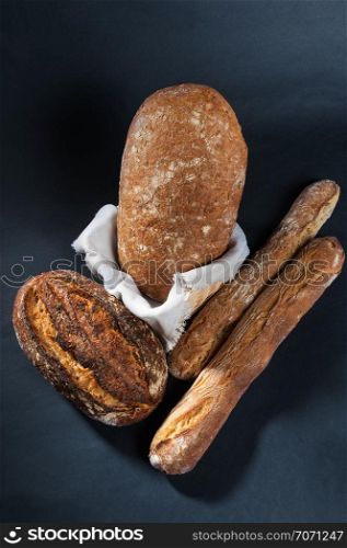 buckwheat bread in a wicker basket with a napkin on dark background