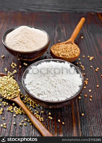 Buckwheat flour from green and brown cereals in two bowls, groats in spoons and on the table against the background of a dark wooden board