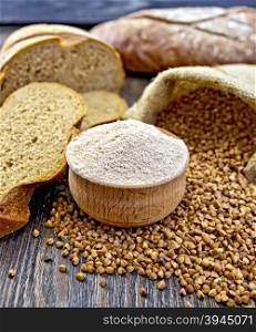 Buckwheat flour in a wooden bowl, buckwheat in the bag, the bread slices on a wooden boards background