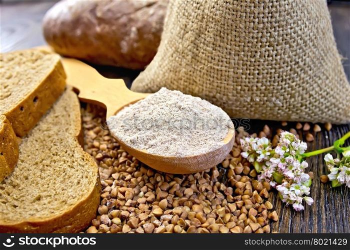 Buckwheat Flour in a wooden spoon buckwheat in a bag on the table, slices of bread, buckwheat flower on the background of wooden boards