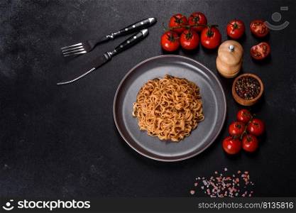 Buckwheat flour noodles with sauce, sesame, herbs and spices on a dark concrete background. Asian cuisine. Buckwheat flour noodles with sauce, sesame, herbs and spices on a dark concrete background