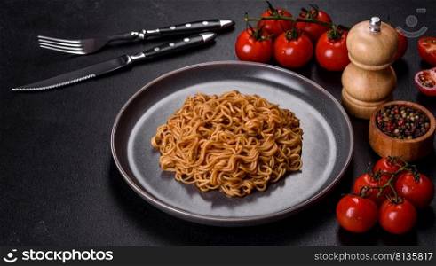 Buckwheat flour noodles with sauce, sesame, herbs and spices on a dark concrete background. Asian cuisine. Buckwheat flour noodles with sauce, sesame, herbs and spices on a dark concrete background