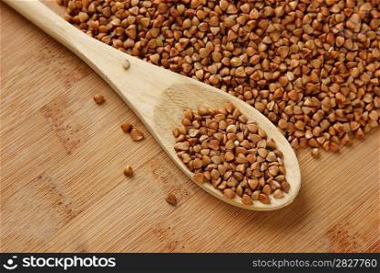 buckwheat groats and wooden spoon on the kitchen table