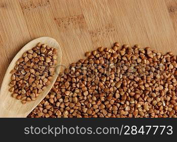 buckwheat groats and wooden spoon on the kitchen table