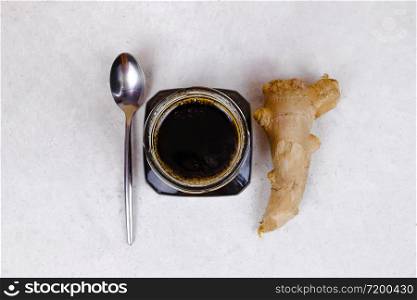 Buckwheat honey, ginger and spoon flat lay. Natural medicine, healthy food, ethnoscience, strengthening immunity. Horizontal picture with copy space, close-up, shallow depth of field.