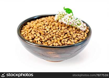 Buckwheat in a brown bowl with buckwheat flower isolated on white background