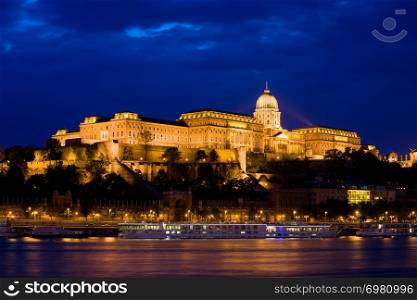 Buda Castle (Royal Palace) by the Danube river illuminated at night in Budapest, Hungary.