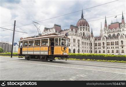 BUDAPEST, HUNGARY - MAY 03, 2014: Yellow vintage tram on the streets of the city on the background of the parliament building. Budapest. Hungary