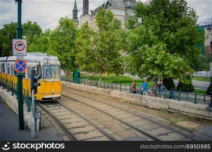 Budapest, Hungary - September 16, 2015: Tram number 2 traveling in the city center of Budapest Hungary in September 16, 2015. Unidentified people walking next to on the sidewalk.