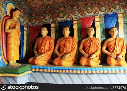 Buddha and seated monks in Mulkirgala cave, Sri Lanka