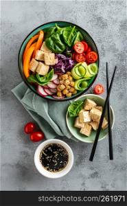 Buddha bowl salad with chickpeas, sweet pepper, tomato, cucumber, red cabbage kale, fresh radish, spinach leaves and tofu cheese, healthy balanced clean eating concept, top view, flat lay
