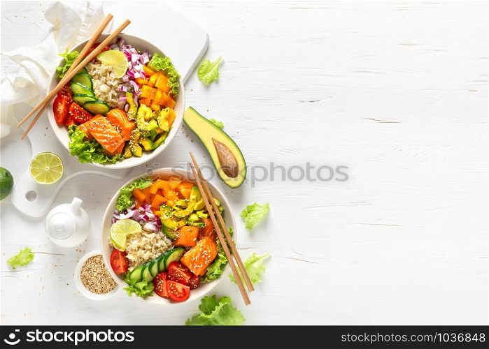 Buddha bowl with grilled salmon fish, fresh cucumber, tomato, onion, sweet pepper, avocado, lettuce salad and rice, healthy balanced eating