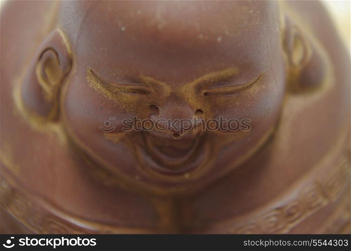 Buddha Happy Face. Ancient clay figurine buddha close up.