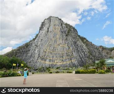 Buddha laser carved and inlayed with gold on the cliff at Khao Chee Chan in Pattaya, Thailand