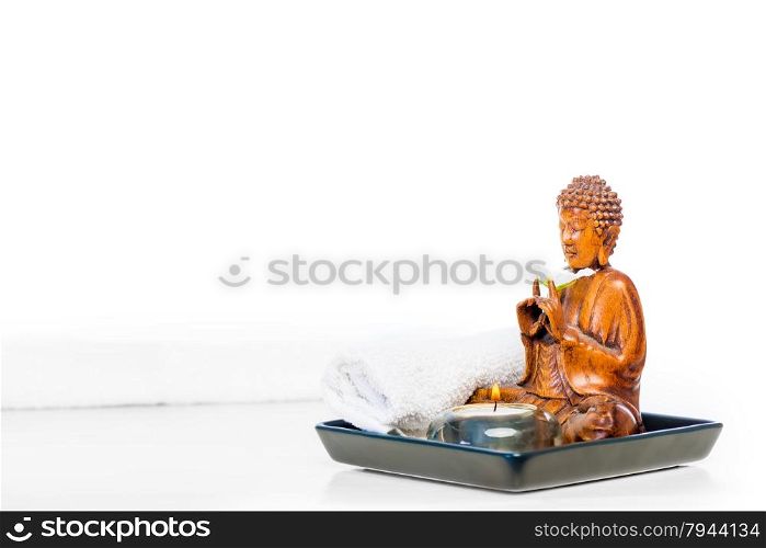 Buddha statue and candle on a white background