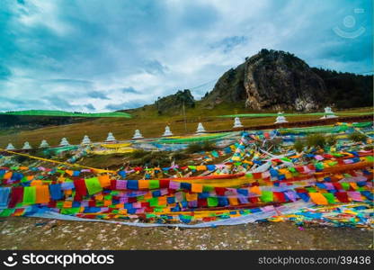 Buddhist prayer flags the holy traditional flag along site the way to Holy snow mountains in Yading nature reserve, China.