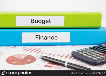 Budget and Finance words on labels with document binders, graphs and business reports