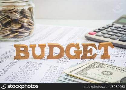 Budget and financial management for business project.. Wooden alphabet word Budget putting on accounting stagement and paperwork with money saving jar, calculator and dollar cash on office table. Concept of financial management and business project.