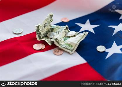 budget, money, finance, financial crisis and nationalism concept - close up of american flag and cent coins with crumpled dollar banknote